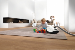 Staubsauger auf Teppich mit Kind